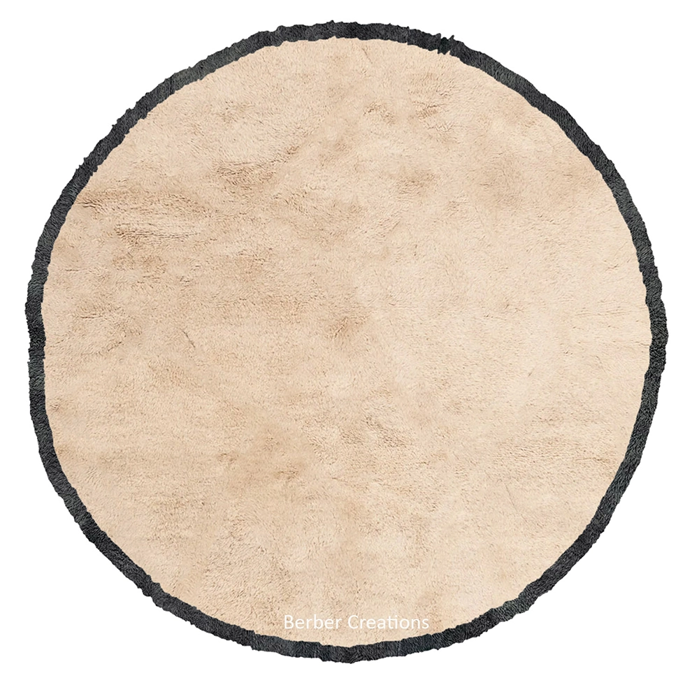 Handcrafted round Moroccan Beni Ourain rug made of natural cream wool with a thick charcoal grey braided border, shown on a white background.