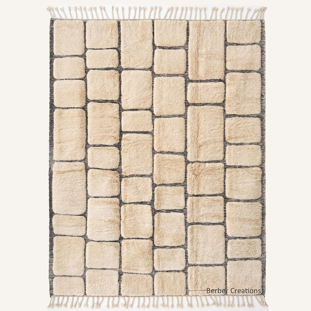 The Alabaster Alley – Sculptural ivory and charcoal custom Moroccan rug with 3D cobblestone design, hand-knotted by Berber Creations.