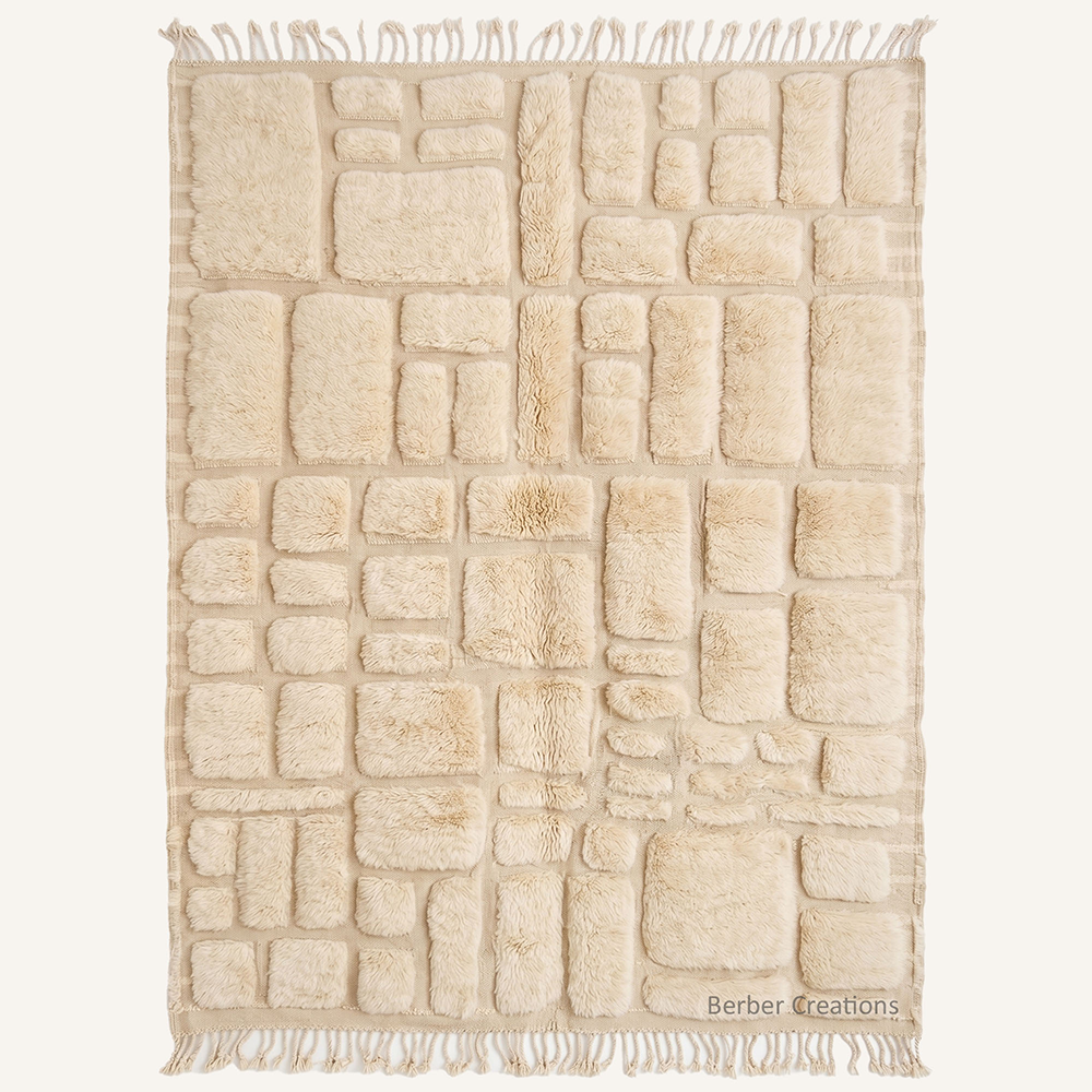 Sahara Mosaic Moroccan rug by Berber Creations, featuring a neutral cream wool with a 3D geometric block texture and hand-braided tassels.