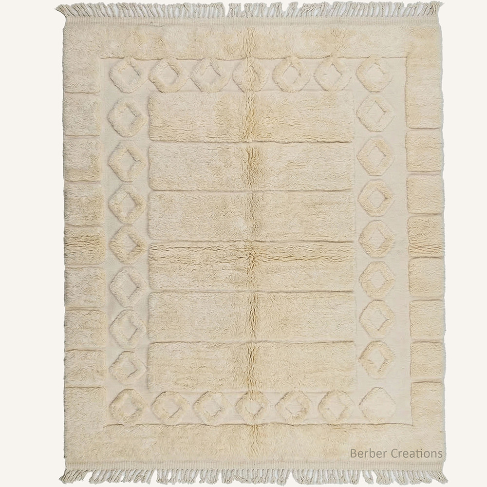 Custom-sized 3D textured Moroccan rug "The Alabaster Frame" by Berber Creations. Features a raised diamond border and rectangular grid in cream wool. Sculptural high-low pile rug made in our Atlas workshop