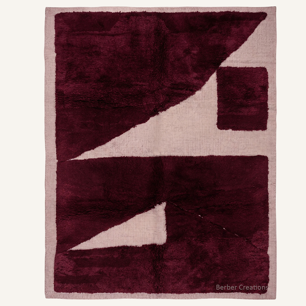 The Burgundy Meridian authentic deep burgundy and dusty-rose cream Moroccan wool rug, featuring an abstract geometric 3D high-low pattern with oversized plush shapes.