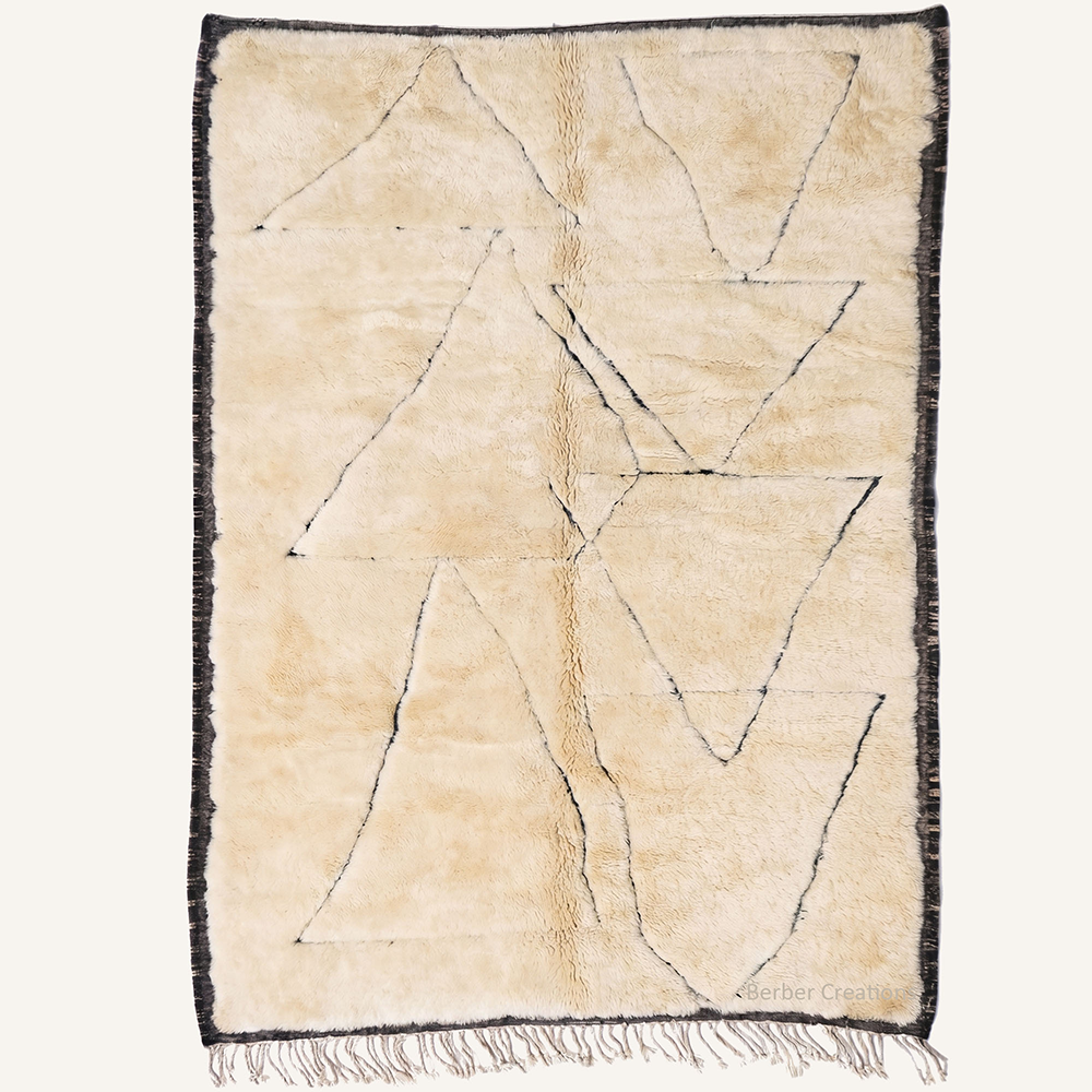 Minimalist geometric "Anzar" Moroccan wool rug with plush pile, featuring abstract charcoal line triangles on an ivory backdrop with a dark frame, hand-knotted by Berber Creations.