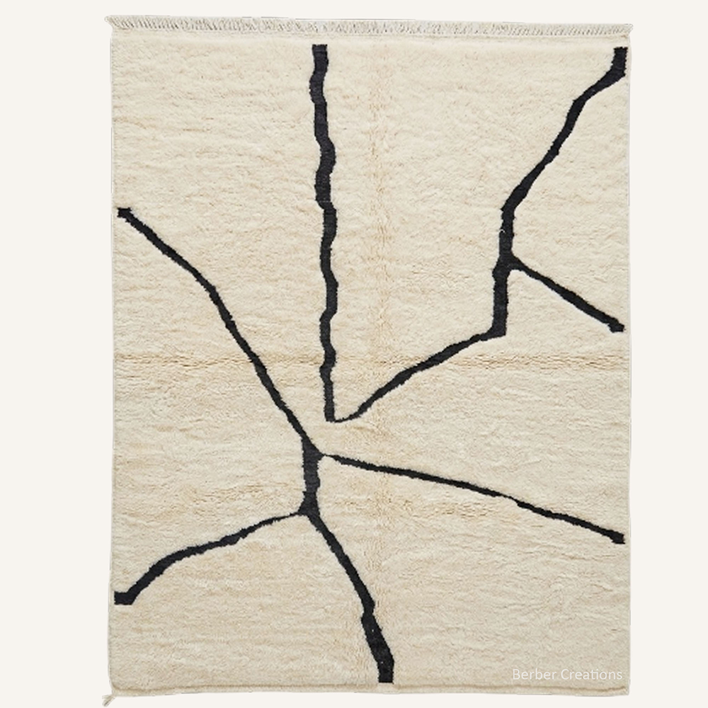 Minimalist "Fractured Earth" Moroccan wool rug with plush cream pile, featuring abstract charcoal black lines, hand-knotted by Berber Creations.