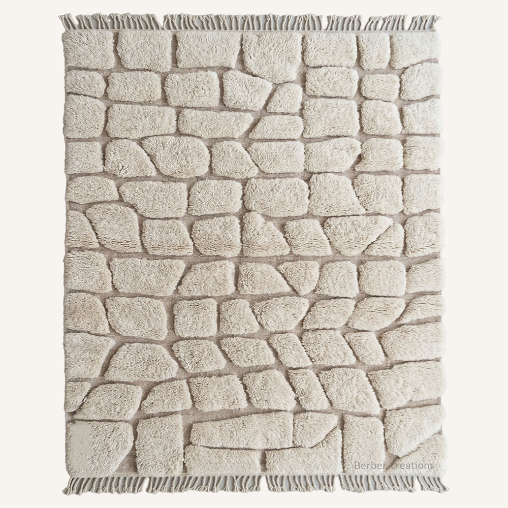 Abstract 3D high-low pile "Imilchil" Moroccan wool rug featuring raised cobblestone geometric panels of cream over an ivory woven base, hand-knotted by Berber Creations