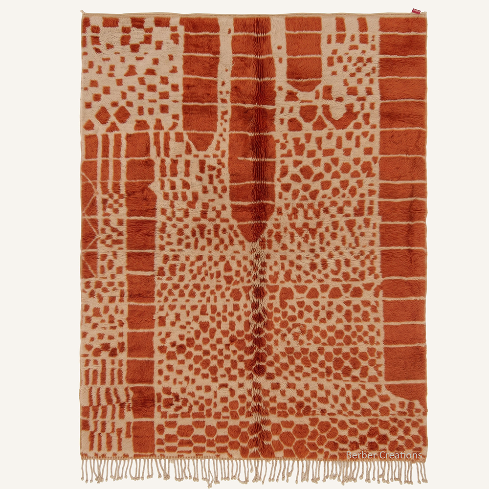 Malika abstract tribal hand-knotted Azilal wool rug featuring warm terracotta and cream patterns, crafted in the Berber Creations workshop.