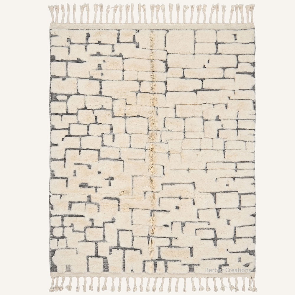 Modernist geometric "Tasnim" Moroccan wool rug with plush pile, featuring an abstract charcoal black brick pattern on an ivory backdrop with fringed borders, hand-knotted by Berber Creations.