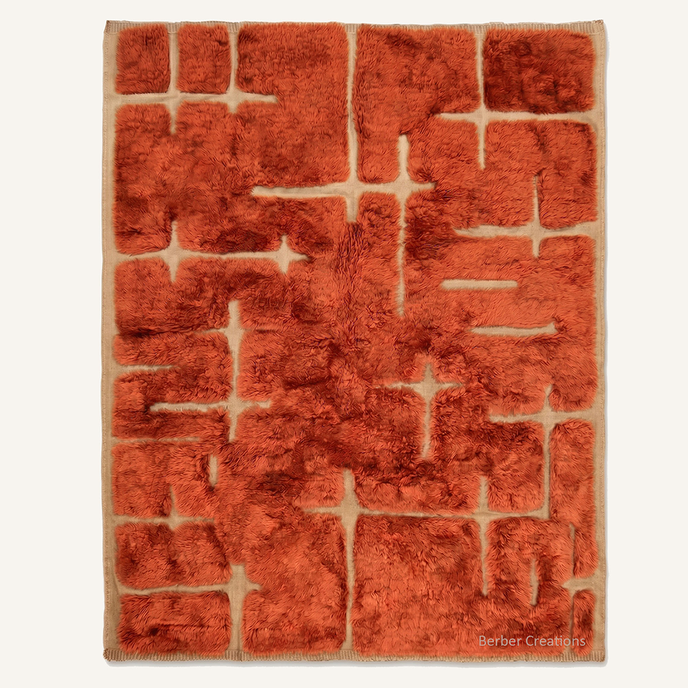Yasmine abstract carved hand-knotted Beni Mrirt wool rug featuring a star-cut Rust Orange pattern over a cream base, crafted in the Berber Creations workshop.