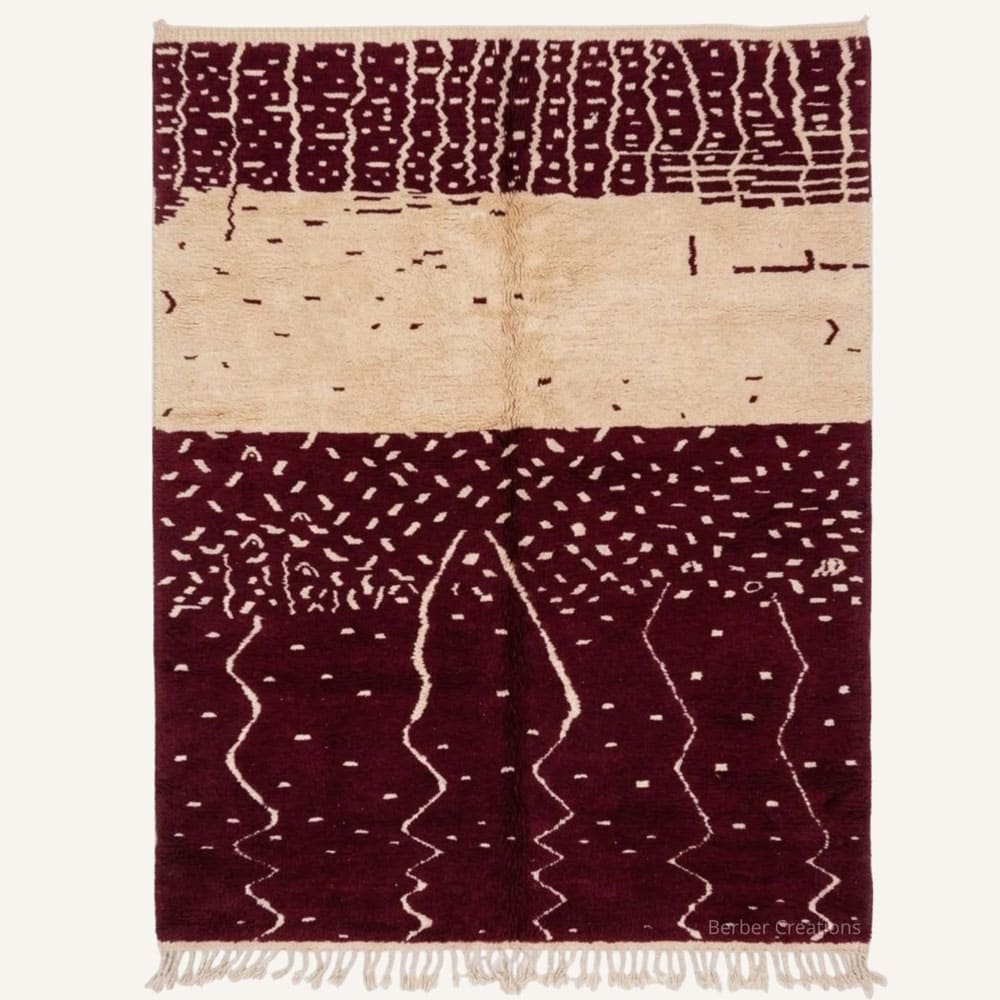 Targa handmade Moroccan Berber wool rug featuring a colorblocked composition with a top cream band patterned in dark ladder motifs and a deep burgundy base woven with vertical zigzag lines, dot dash accents